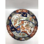 An early 20th Century Japanese Imari charger, the centre field decorated with panels of figures