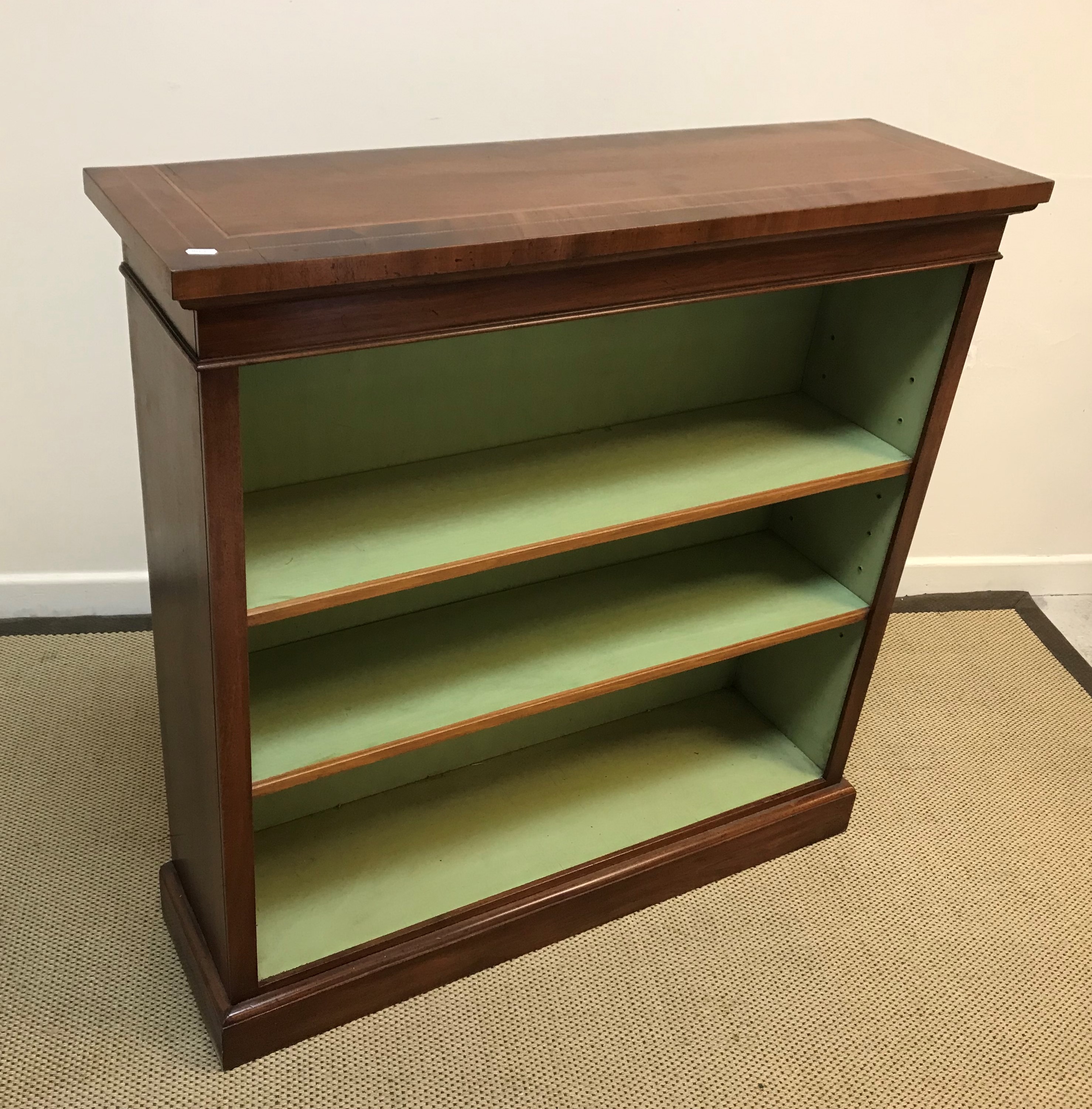 A mahogany open bookcase in the Georgian taste, the figured top with inlaid stringing and double