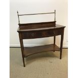 An Edwardian mahogany bow fronted serving table with brass gallery back over a single drawer with