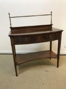 An Edwardian mahogany bow fronted serving table with brass gallery back over a single drawer with