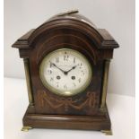 An Edwardian mahogany and inlaid dome top mantel clock of architectural form, with brass column