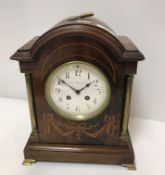 An Edwardian mahogany and inlaid dome top mantel clock of architectural form, with brass column