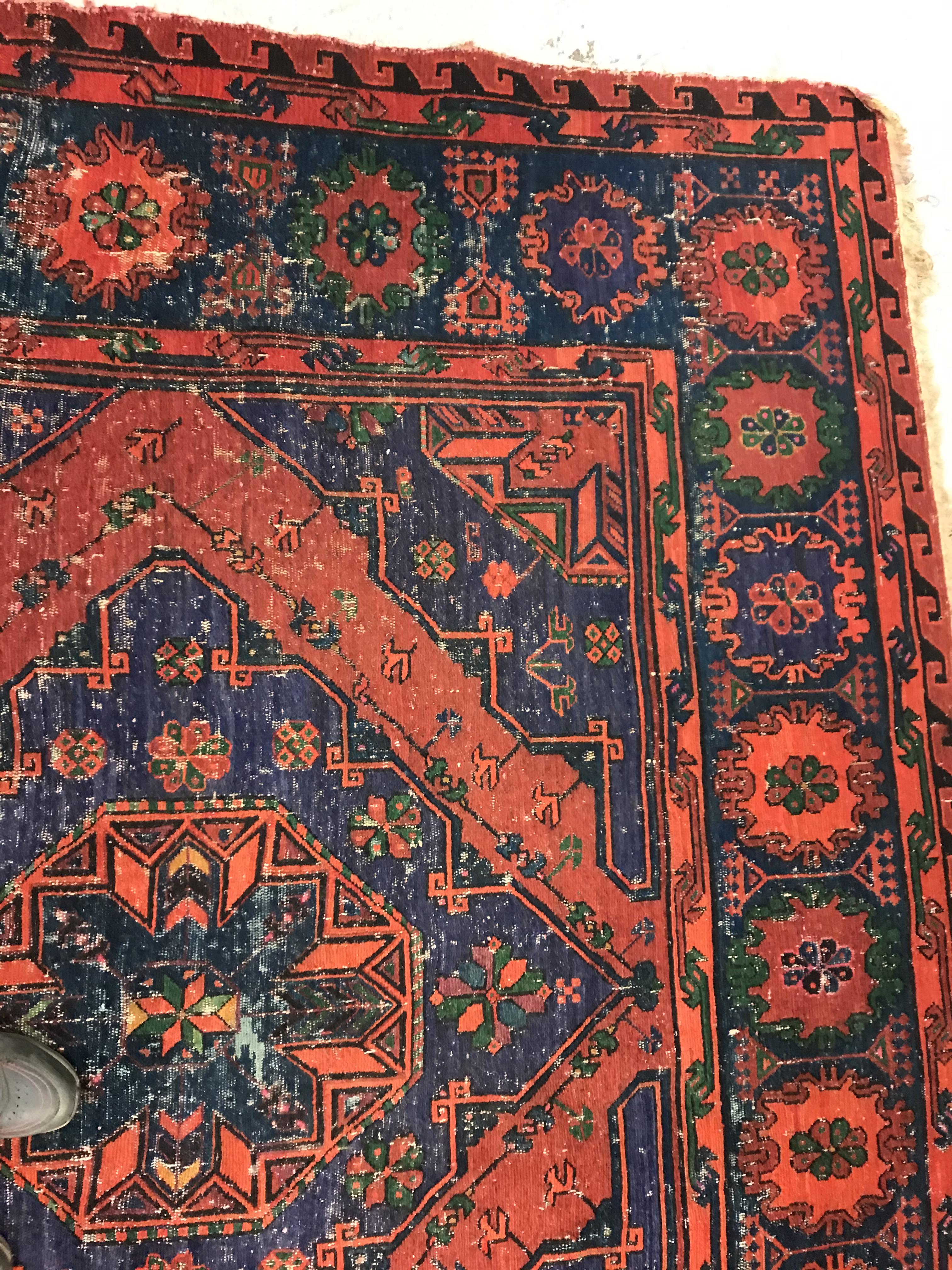 A Persian rug with three repeating lozenge medallions on a red and blue ground, within a blue, red - Image 8 of 20