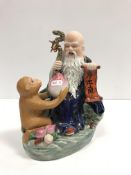 A 20th Century porcelain figure group as a Taoist sage with staff and scroll being presented a large