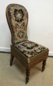 A Victorian walnut framed spoon back prie a dieu type chair, the back and seat with needlework
