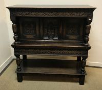 An early to mid 20th Century oak Gothic Revival court cupboard, the plain top over a scrolling