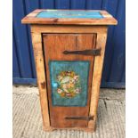 A Continental pine single door cupboard, the top and door painted with panels of flowers on a blue