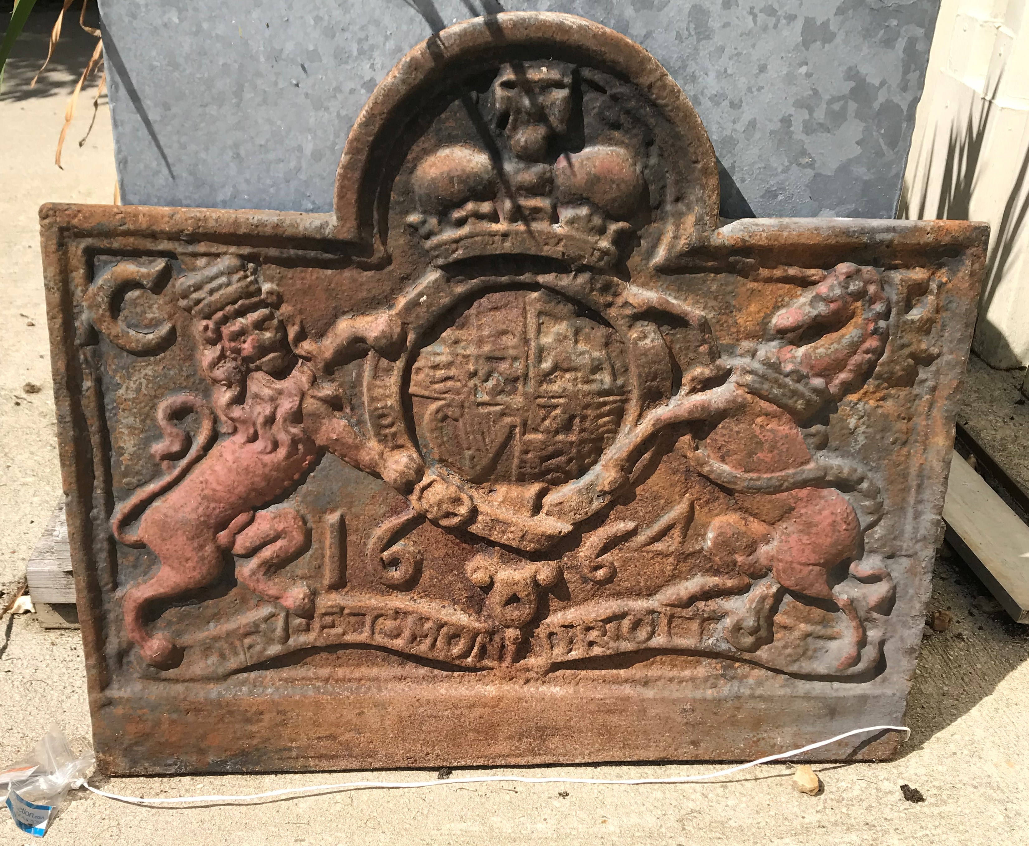 A cast iron fire back with lion and unicorn motifs and dated 1664, initialled "CR" to corners, 74 cm
