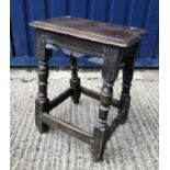 A 17th Century joined oak stool, the single piece top with moulded edge over a carved frieze on
