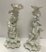 A pair of 19th Century Dresden blanc de chine candle holders, one as a couple of girls holding aloft