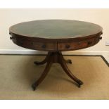 A Victorian Regency style mahogany drum table, the top with tooled and gilded leather insert over