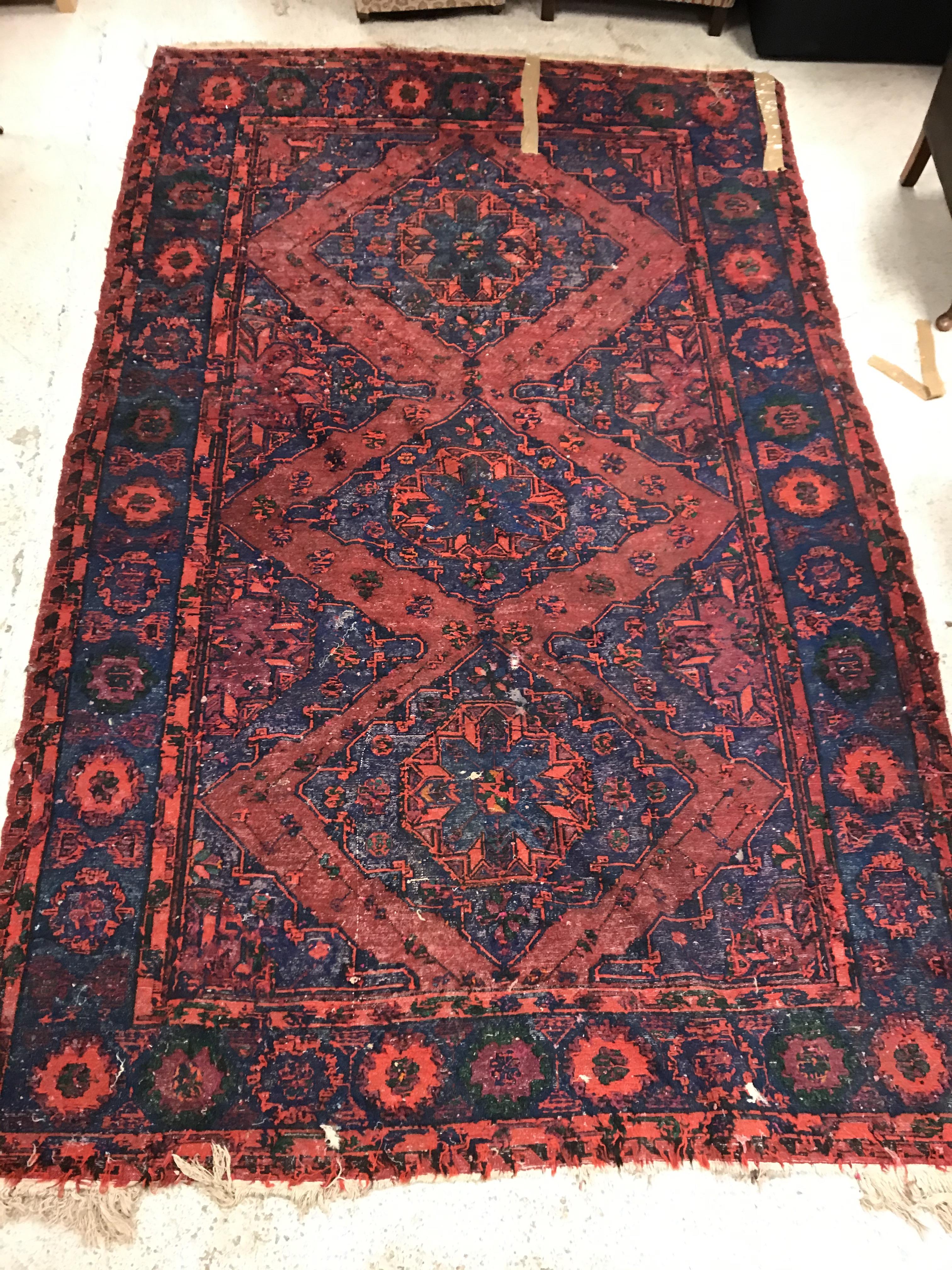 A Persian rug with three repeating lozenge medallions on a red and blue ground, within a blue, red - Image 19 of 20