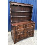 A modern oak dresser in the circa 1700 manner, the two tier boarded plate rack over two drawers