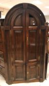 A George III oak free-standing barrel back corner cupboard, the dome top with moulded cornice