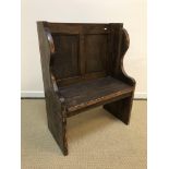 An oak and pine single seat pew or hall bench, the twin panel back over a single plank seat,