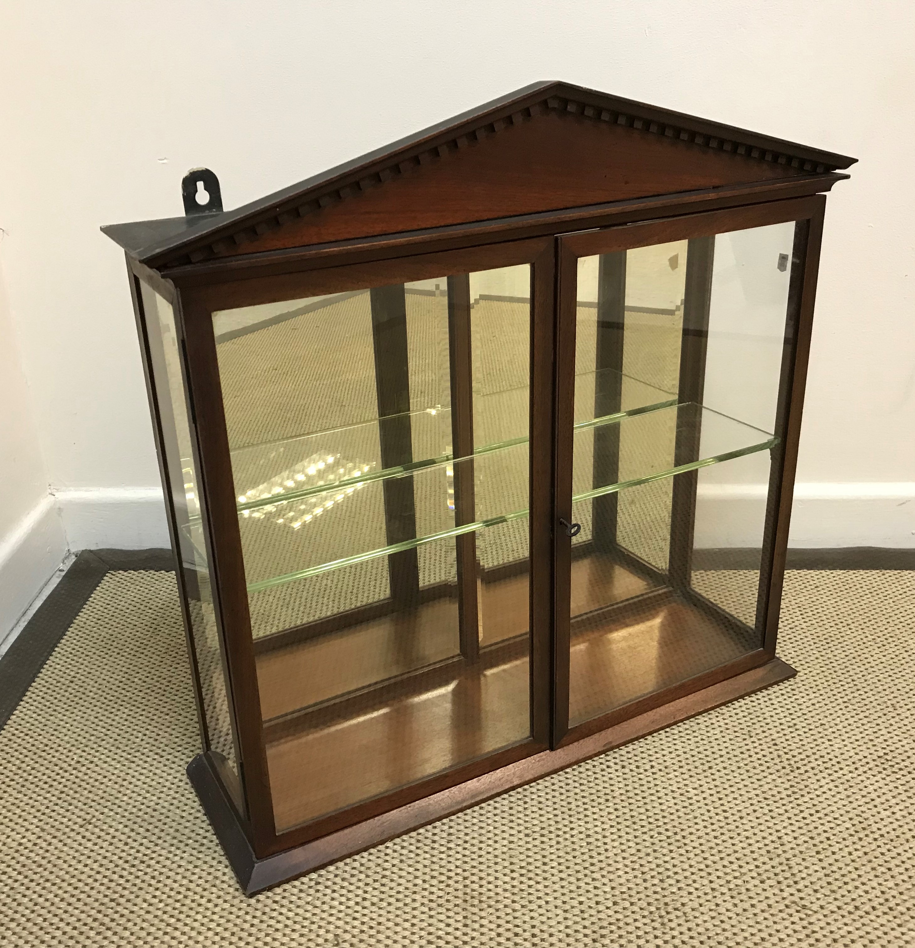 A Victorian mahogany glazed hanging display cabinet with architectural dentil cornice over two doors