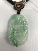 A green and white jade pendant as a dragon with further carving verso, approx 5.6 cmx 3.6 cm, on a