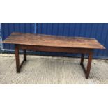 A 19th Century oak refectory style dining table, the four plank top above a plain frieze, raised