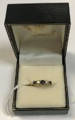An 18 carat gold ladies dress ring set with three graduated sapphires interspersed by two