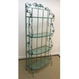 A modern green painted wrought iron shelf unit with grape and vine decoration, the folding sides
