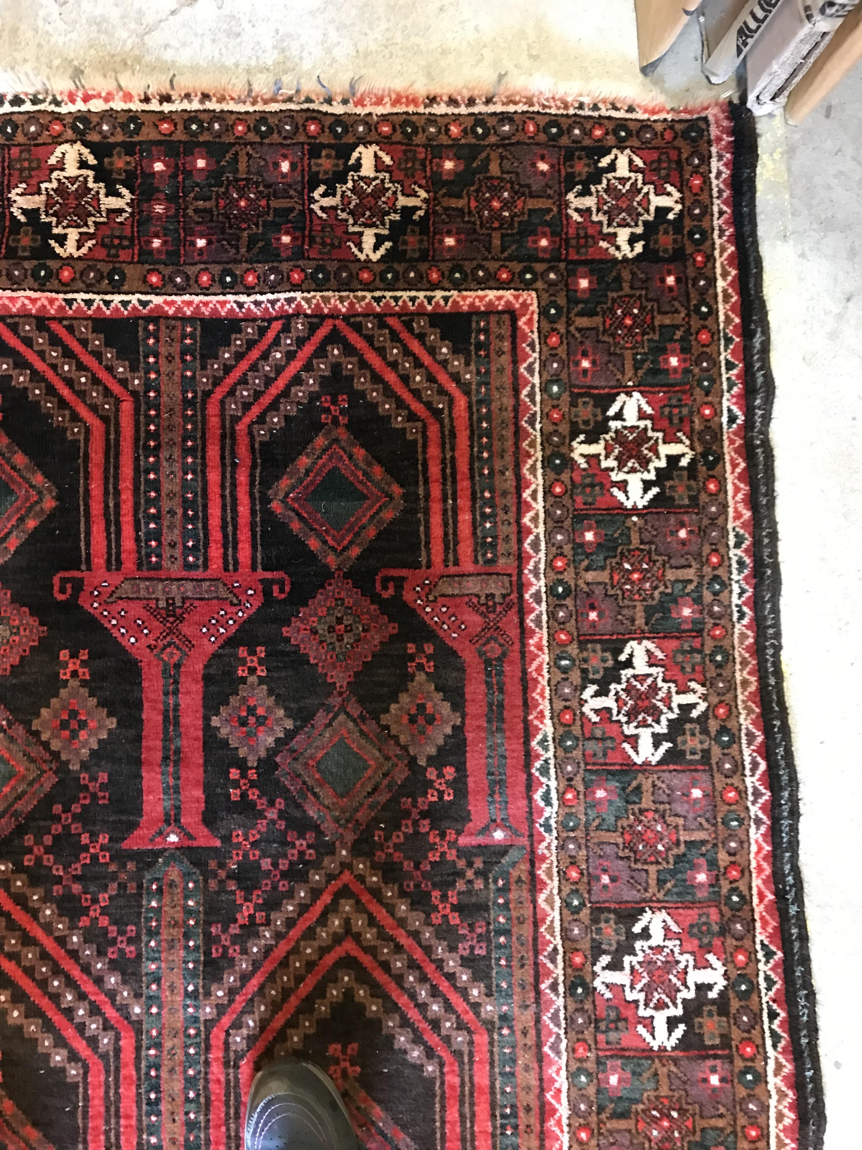 A Persian carpet, the central panel set with repeating arch decoration on a black and red ground, - Image 11 of 17