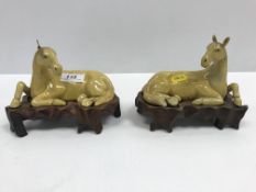 A pair of 19th Century Chinese famille jaune figures of recumbent horses, 15.8 cm long x 10.7 cm