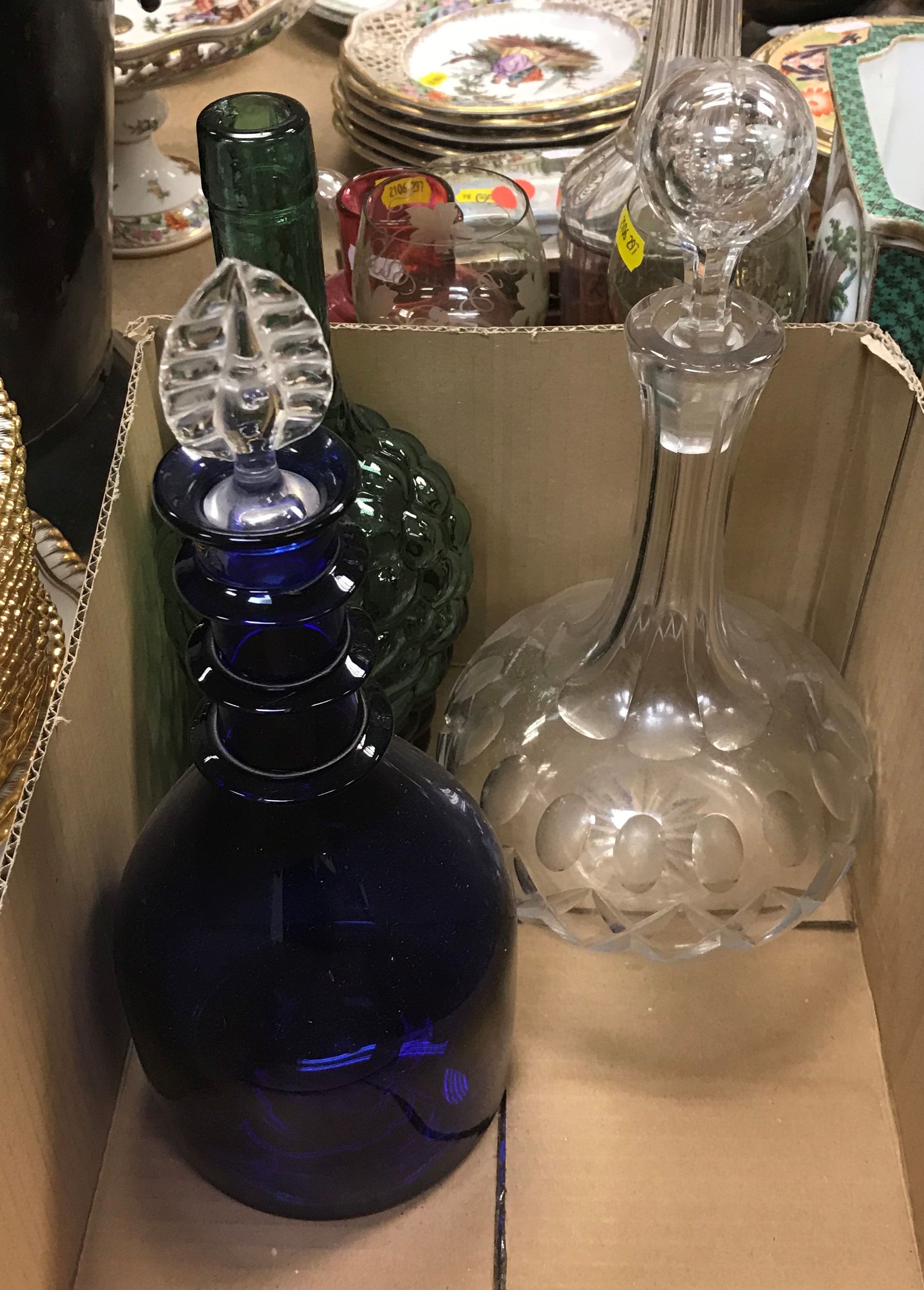 A box containing a collection of four decanters including a pair of green glass grape and vine