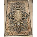 A Persian rug, the central panel set with floral decorated oval medallion on a dark blue and pale