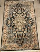 A Persian rug, the central panel set with floral decorated oval medallion on a dark blue and pale