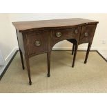 A 19th Century mahogany serpentine fronted sideboard with central drawer flanked by deep drawer