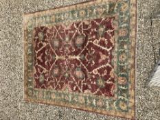 A Ziegler design carpet, the central panel set with all-over scrolling foliate decoration on a red