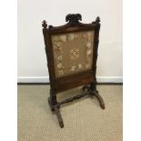 An early Victorian rosewood framed fire screen with needlework panel (formerly adjustable now