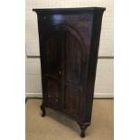A late George III mahogany corner cupboard, the moulded cornice over two arch panelled doors
