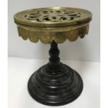 A heavy Victorian brass and iron trivet, the pierced top with castellated frieze on a stepped