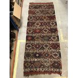 A fine Caucasian tribal carpet with repeating green, blue and red medallions, approx 246 cm x 102