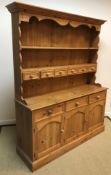 A modern pine dresser, the boarded two tier plate rack with six small drawers over three drawers and