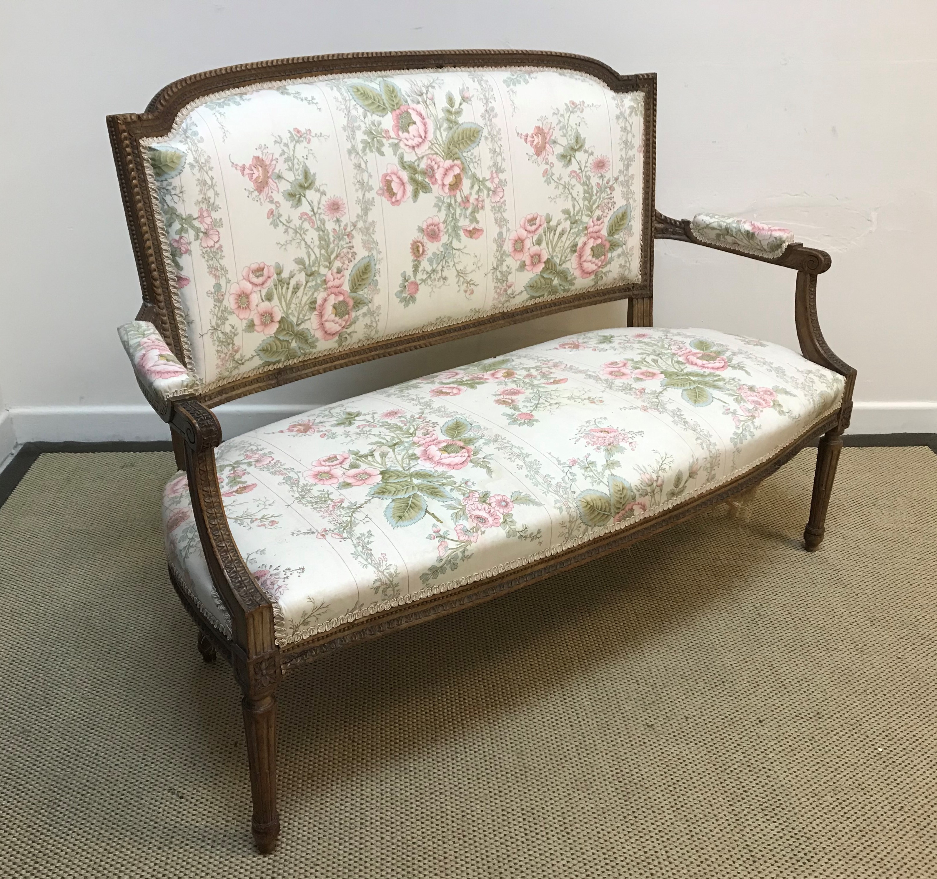 A circa 1900 carved walnut framed salon settee in the Louis XV taste, floral upholstered and