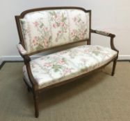 A circa 1900 carved walnut framed salon settee in the Louis XV taste, floral upholstered and