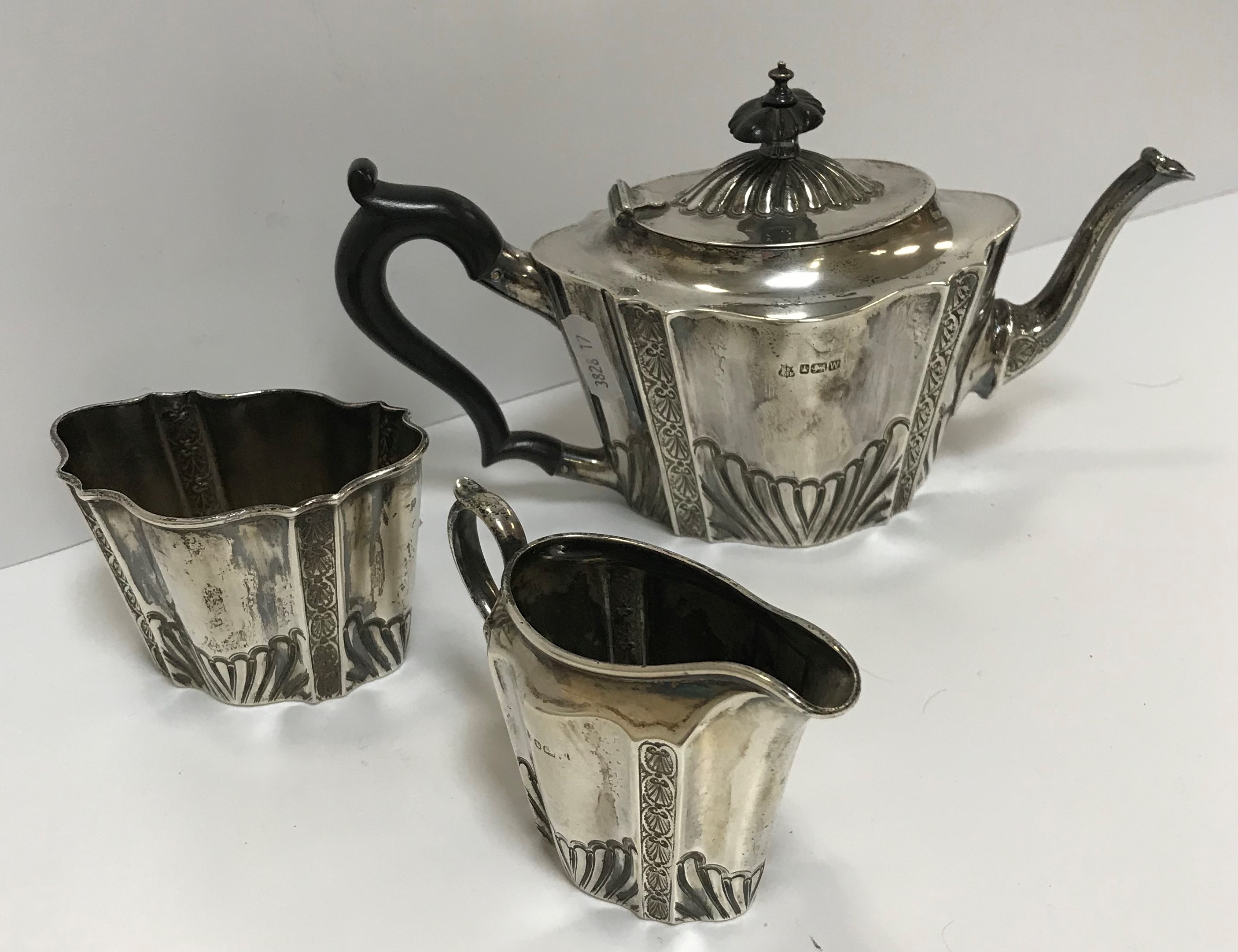 A Victorian silver tête à tête three piece tea set of embossed and fluted form, comprising teapot,