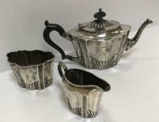 A Victorian silver tête à tête three piece tea set of embossed and fluted form, comprising teapot,