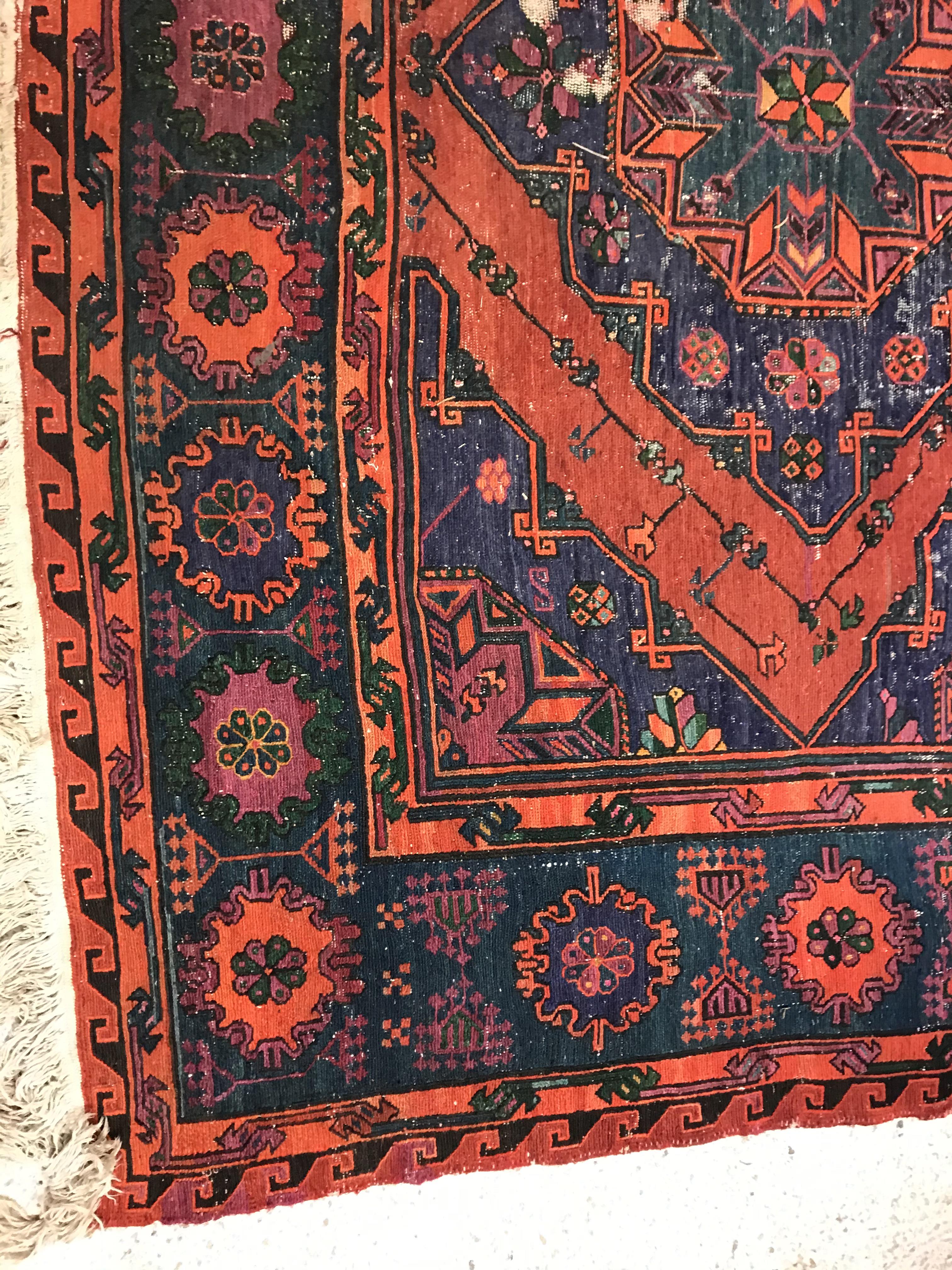 A Persian rug with three repeating lozenge medallions on a red and blue ground, within a blue, red - Image 2 of 20