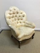 A Victorian buttoned upholstered salon arm chair on rosewood cabriole legs to brass casters 79 cm