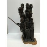 A 20th Century carved coromandel or king ebony Masai figure group depicting eight figures, some