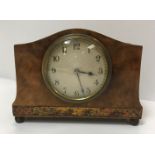 An early 20th Century French walnut cased mantel clock with chinoiserie banded decoration, raised on