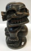 A 20th Century Ugandan carved ebony figure "Jabawoki", a squat fat bellied man, inscribed on label