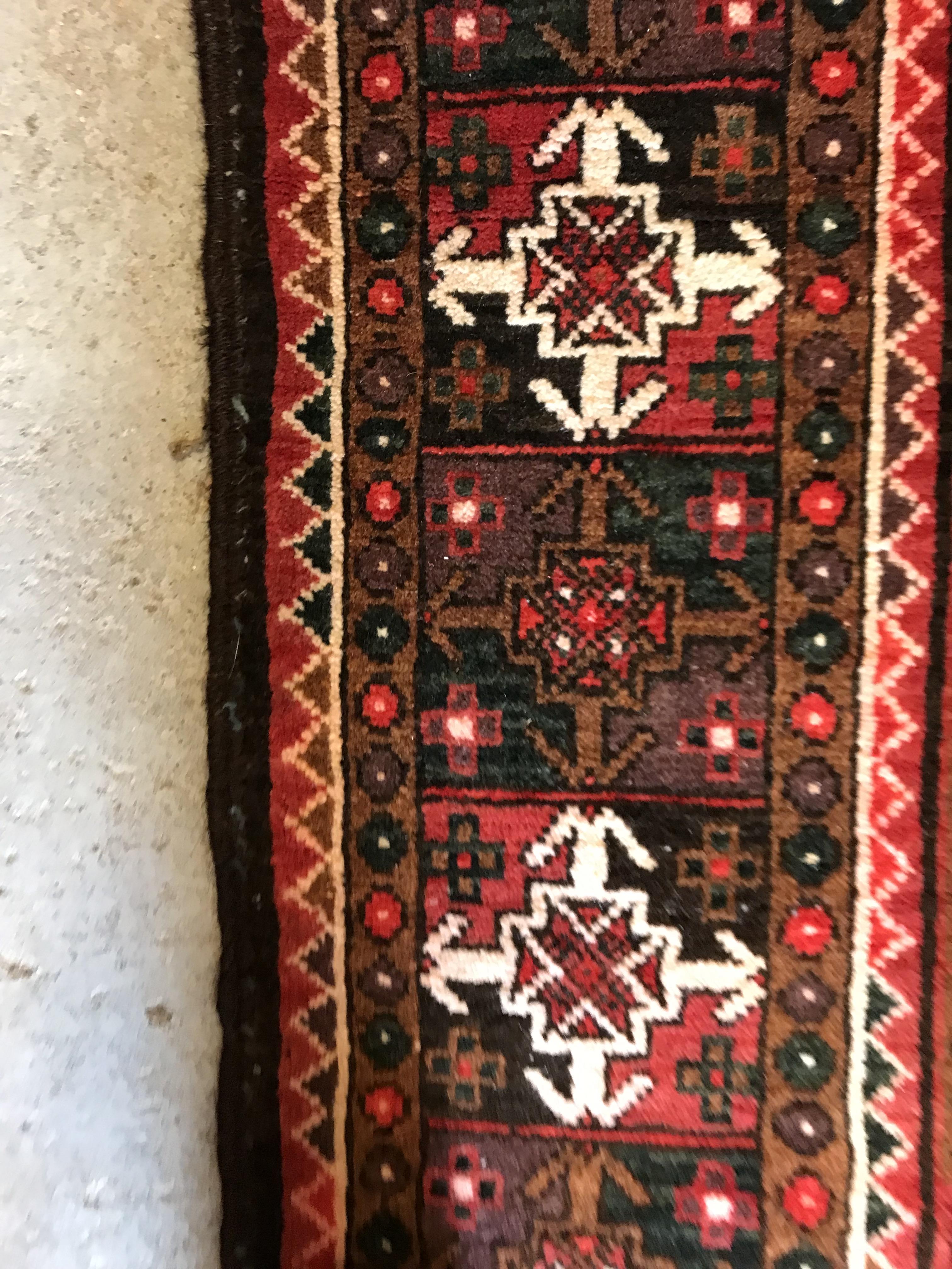 A Persian carpet, the central panel set with repeating arch decoration on a black and red ground, - Image 14 of 17