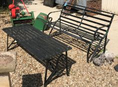 A wrought iron slatted two seat garden bench with scroll arms together with a similar slatted garden