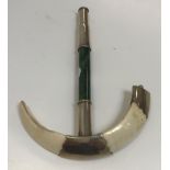 A Burmese white metal mounted boar tusk and jade parasol handle, mounts stamped "S Mc L", 17 cm