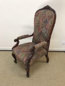 A Victorian mahogany framed high back salon elbow chair with foliate carved top rail and scroll arms