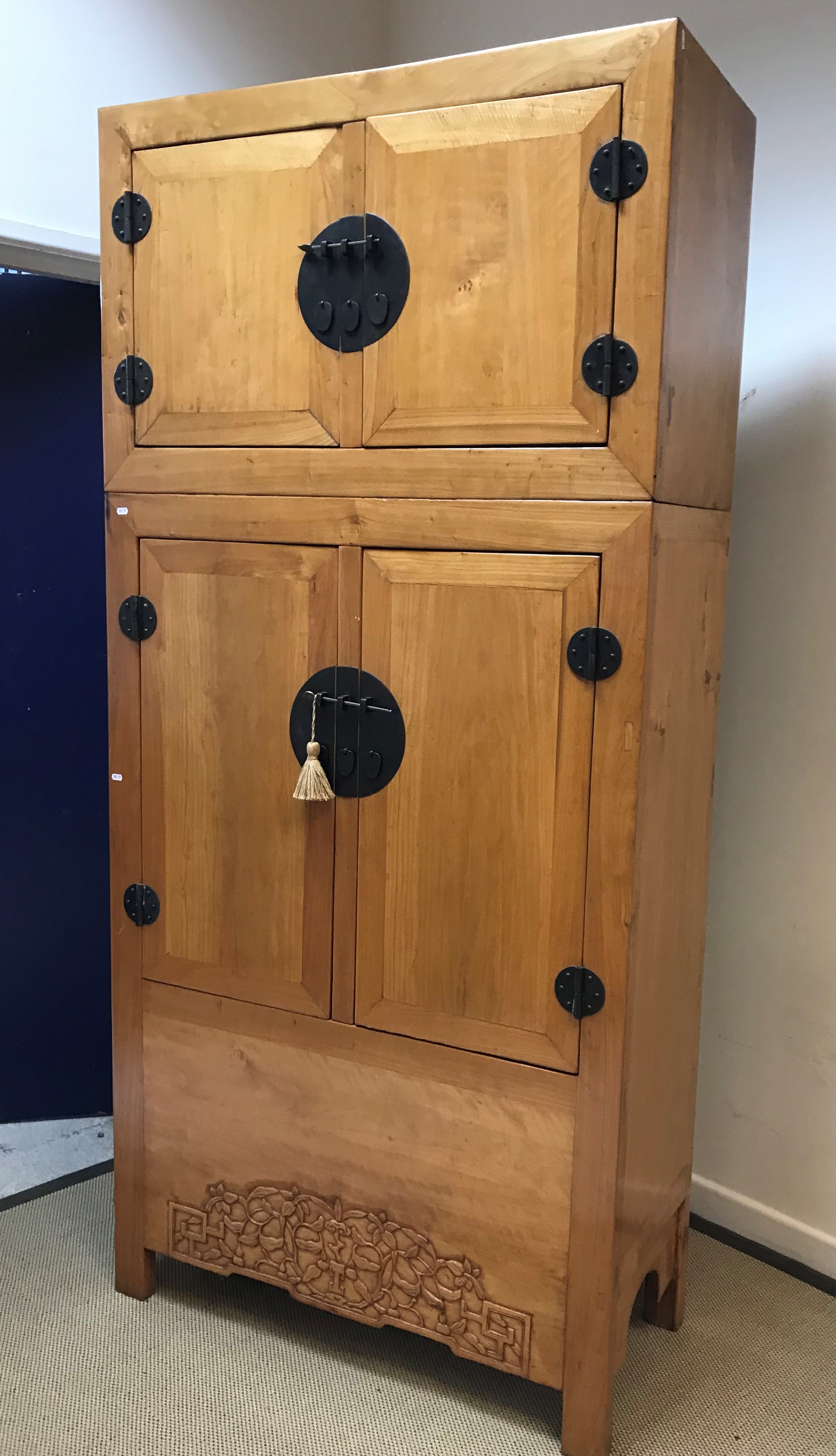 An Eastern blond elm cupboard with two small cupboard doors over two larger cupboard doors and